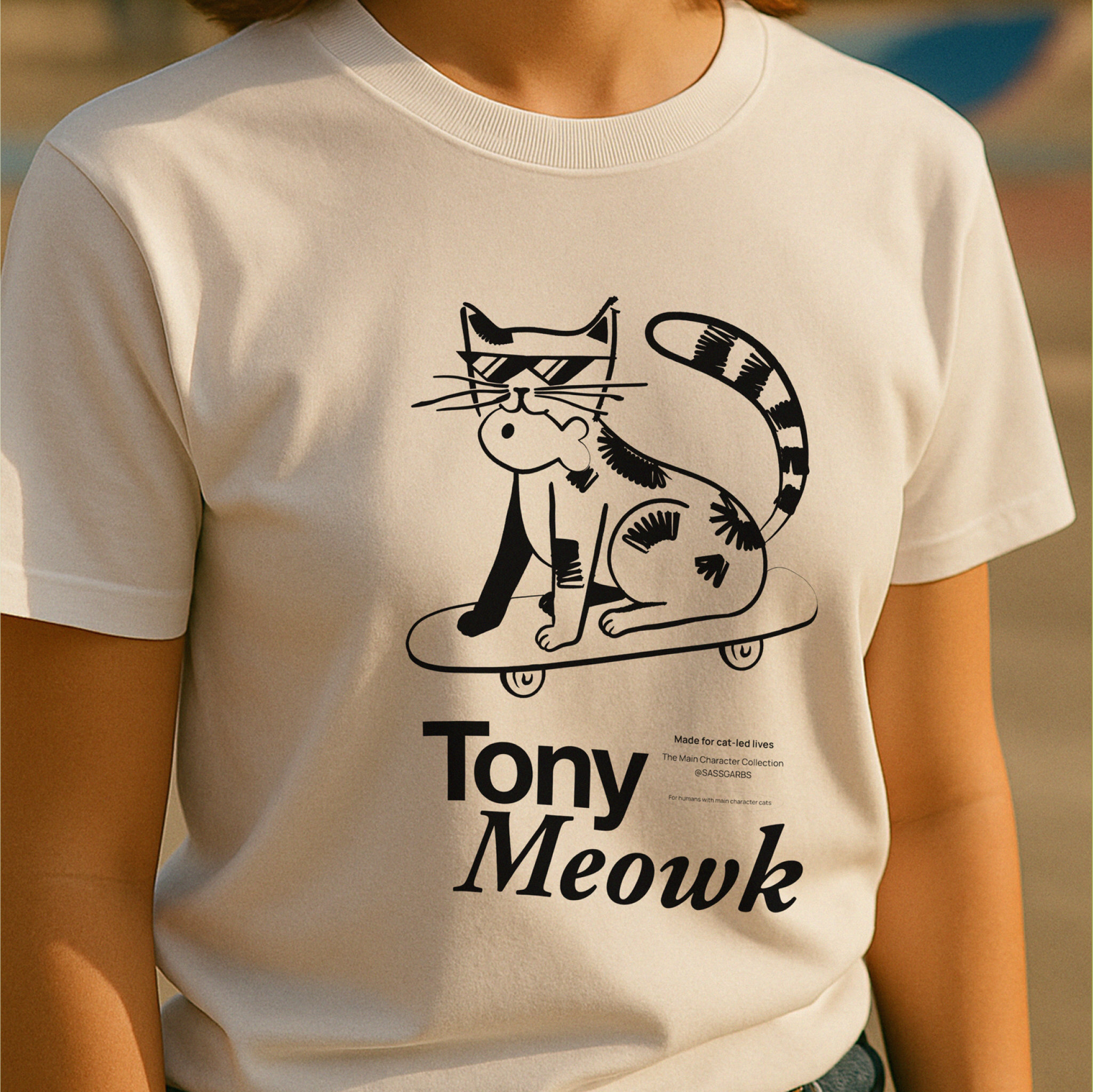 White t-shirt with a black cat graphic and 'Tony Meowk' text on a blurred background
